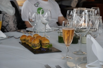 atlantis dx - 25 Jahre Firmenjubiläum Foto: Ein Tisch mit Gläsern und kleinen Burgern