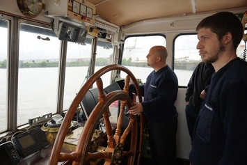 atlantis dx - 25 Jahre Firmenjubiläum Foto: Zwei Männer steuern ein Boot im Steuerhaus