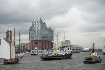 atlantis dx - 25 Jahre Firmenjubiläum Foto: Hamburger Hafenansicht mit mehreren Booten und der Elbphilharmonie im Hintergrund.
